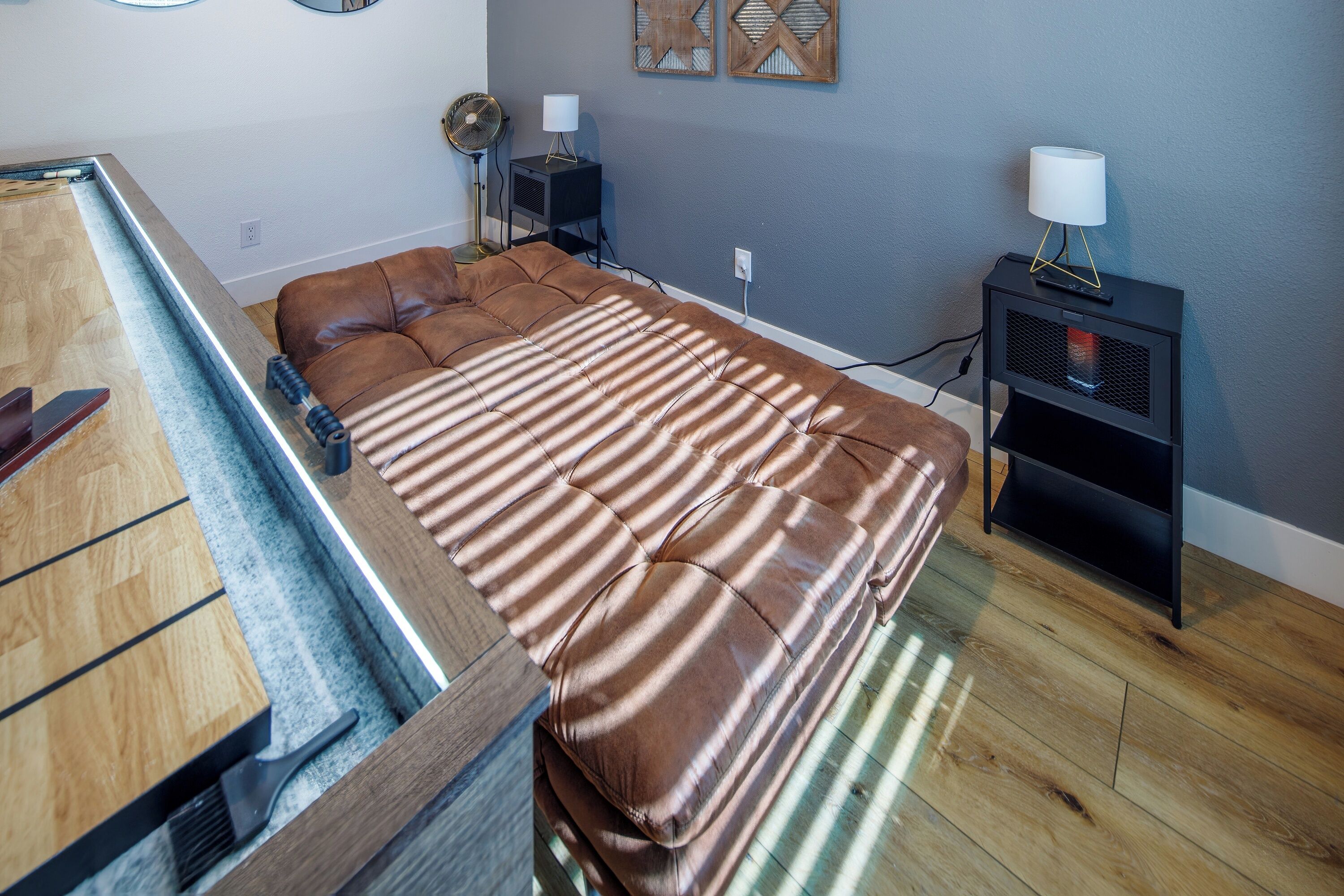 A bedroom with a bed, a nightstand with a lamp, a wall clock, and a radiator.