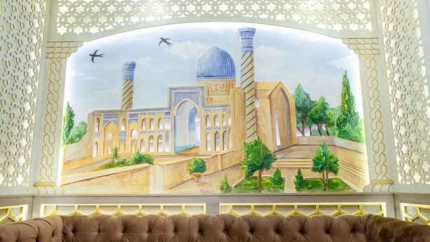 Un mural que muestra una mezquita, un avión colgante y árboles.