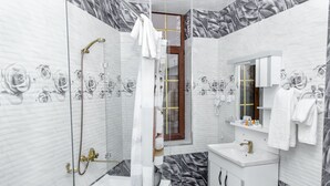 Un baño con ducha, bañera y lavamanos.