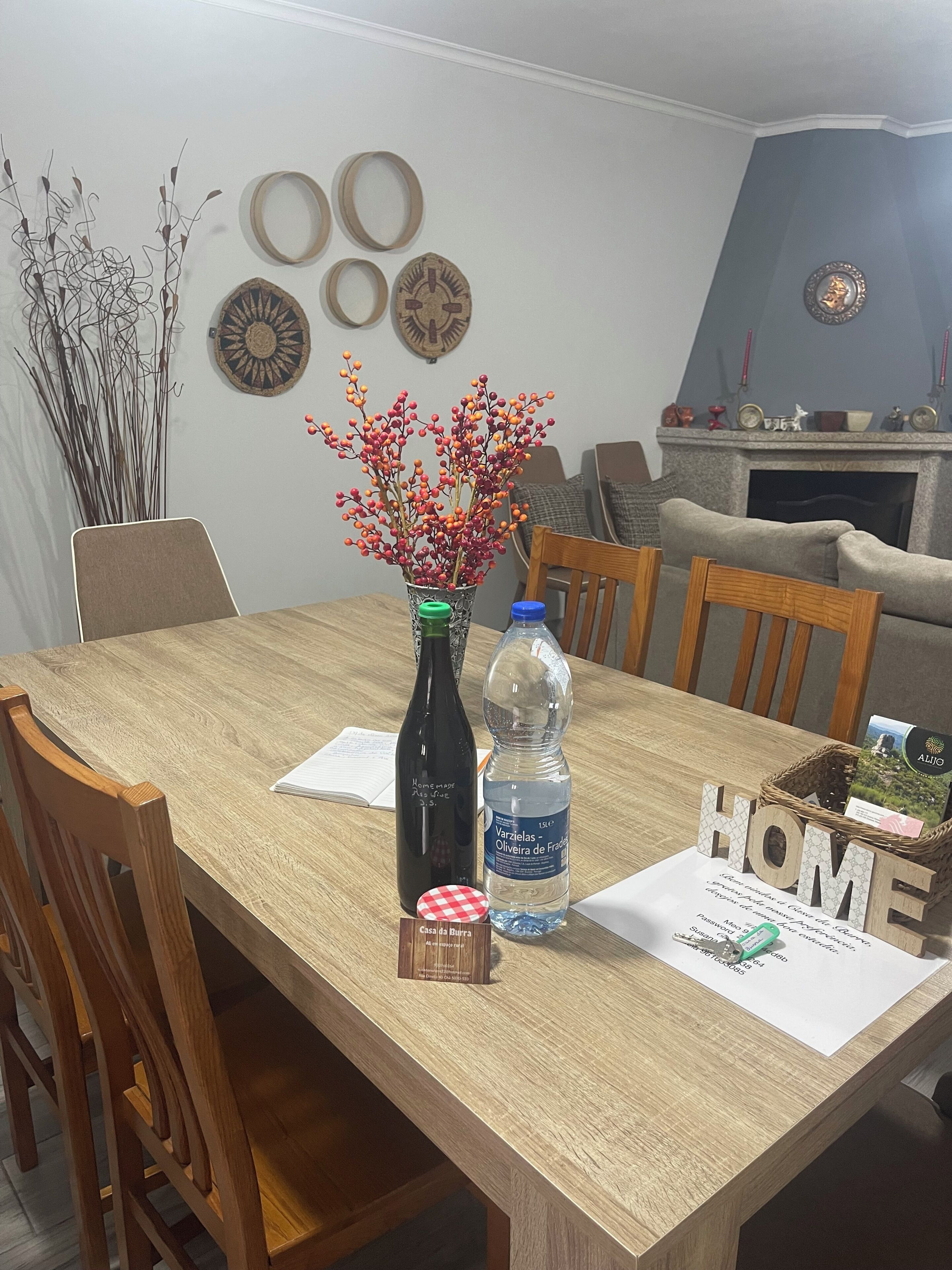 A dining table with a bottle, a water bottle, and a small card.