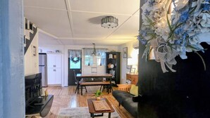 Un salon avec un plancher en bois, une table à manger avec des chaises, un canapé et une table basse.