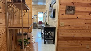 A wooden interior with bunk beds, a desk, and a cart.