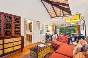 A spacious living area with a wooden cabinet, a sofa set, and a dining area with a view.