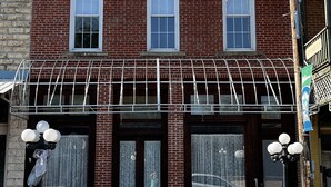 A brick building with a covered entrance and large windows. - Brickhaven Loft on Historic Main Street - walk to Spring River, State Park, more (Mammoth Spring)