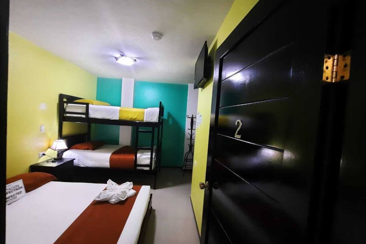 Una habitación de hotel con literas, un armario negro y una puerta con un número.