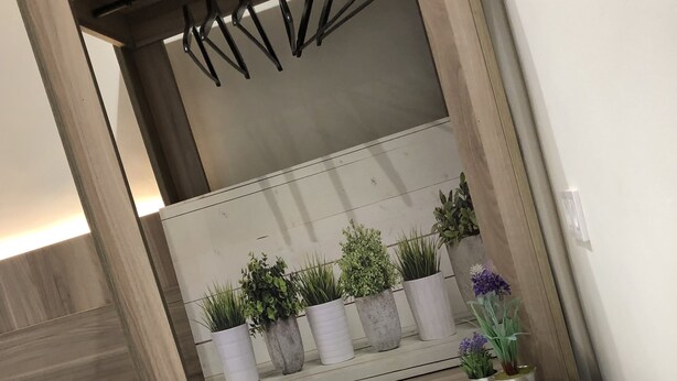 Une salle de bain avec un meuble-lavabo en bois, un miroir et un porte-serviettes.