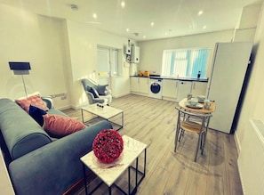 A modern living room with a sofa, coffee table, and a decorative flower arrangement.
