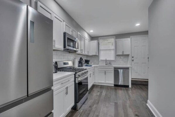 Enjoy cooking in this well-equipped kitchen with a refrigerator, microwave, and gas stove.