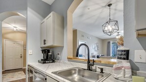 A modern kitchen with a sink, countertop, and cabinets.