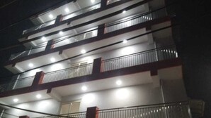 A multi-story building with balconies and railings. - Hotel Abode Inn (New Delhi)