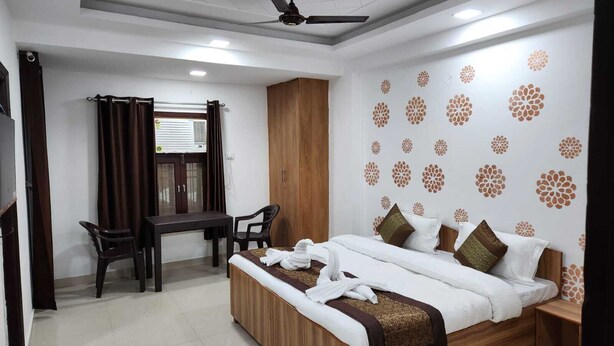 A hotel room with a bed, a desk, and a chair. - Hotel Abode Inn (New Delhi)
