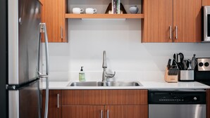 Une cuisine moderne dotée d’armoires en bois, d’appareils électroménagers en acier inoxydable et d’un lave-vaisselle encastré.