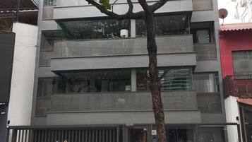 Un immeuble à plusieurs étages, doté d’une architecture moderne, avec des balcons et de grandes fenêtres.