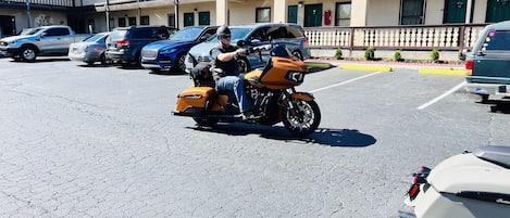 Un parking où sont stationnés plusieurs véhicules, dont une moto avec un side-car.