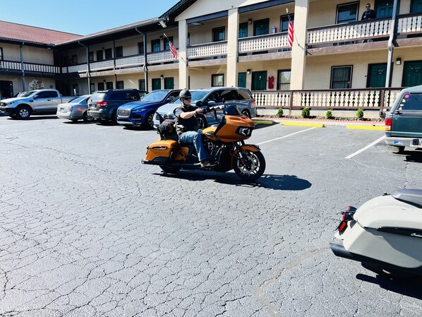 Un parking où sont stationnés plusieurs véhicules, dont une moto avec un side-car.