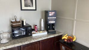 A kitchen counter with a microwave, coffee maker, and a fruit bowl. - Alpine Valley Inn (Helen)