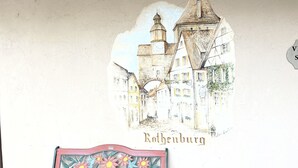 A wall with a mural of a town and a bench. - Alpine Valley Inn (Helen)