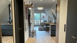 A modern interior with a wooden floor, a kitchen area, and a dining space.
