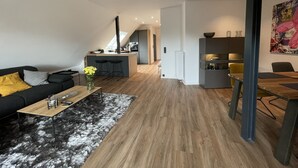 A modern apartment with a living room, kitchen, and dining area.