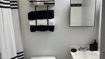 Chuveiro, secador de cabelo, toalhas de banho, sabonete