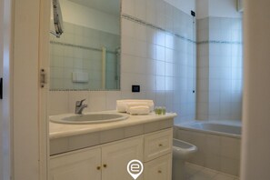 Kombination af bruser/badekar, hårtørrer, bidet, håndklæder