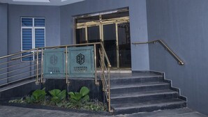 L'ingresso di un hotel con una scala, una porta in vetro e un cartello che riporta 'BENYSTA HOTEL'.