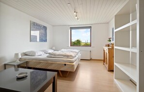 A bedroom with a bed, a desk, a window, and a radiator. - Stunning home in Farsø with WiFi (Farsø)