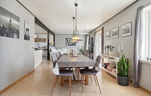 A modern dining area with a long table, chairs, and a hanging light fixture. - Stunning home in Farsø with WiFi (Farsø)
