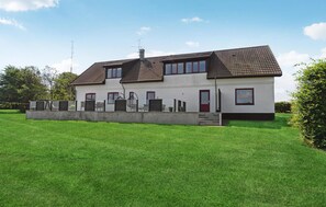 A two-story house with a tiled roof, a front porch with seating, and a well-maintained lawn. - Stunning home in Farsø with WiFi (Farsø)