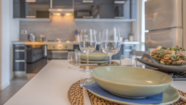 A modern kitchen with a dining area set for a meal. - ANNIE HOUSE - Chic and Comfortable Apartment (Sestri Levante)