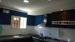 A kitchen with a gas stove, a sink, and a window. - Casa Colinas 2 (Mar del Plata)