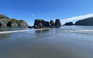 A beach with rocky formations and calm waters.
