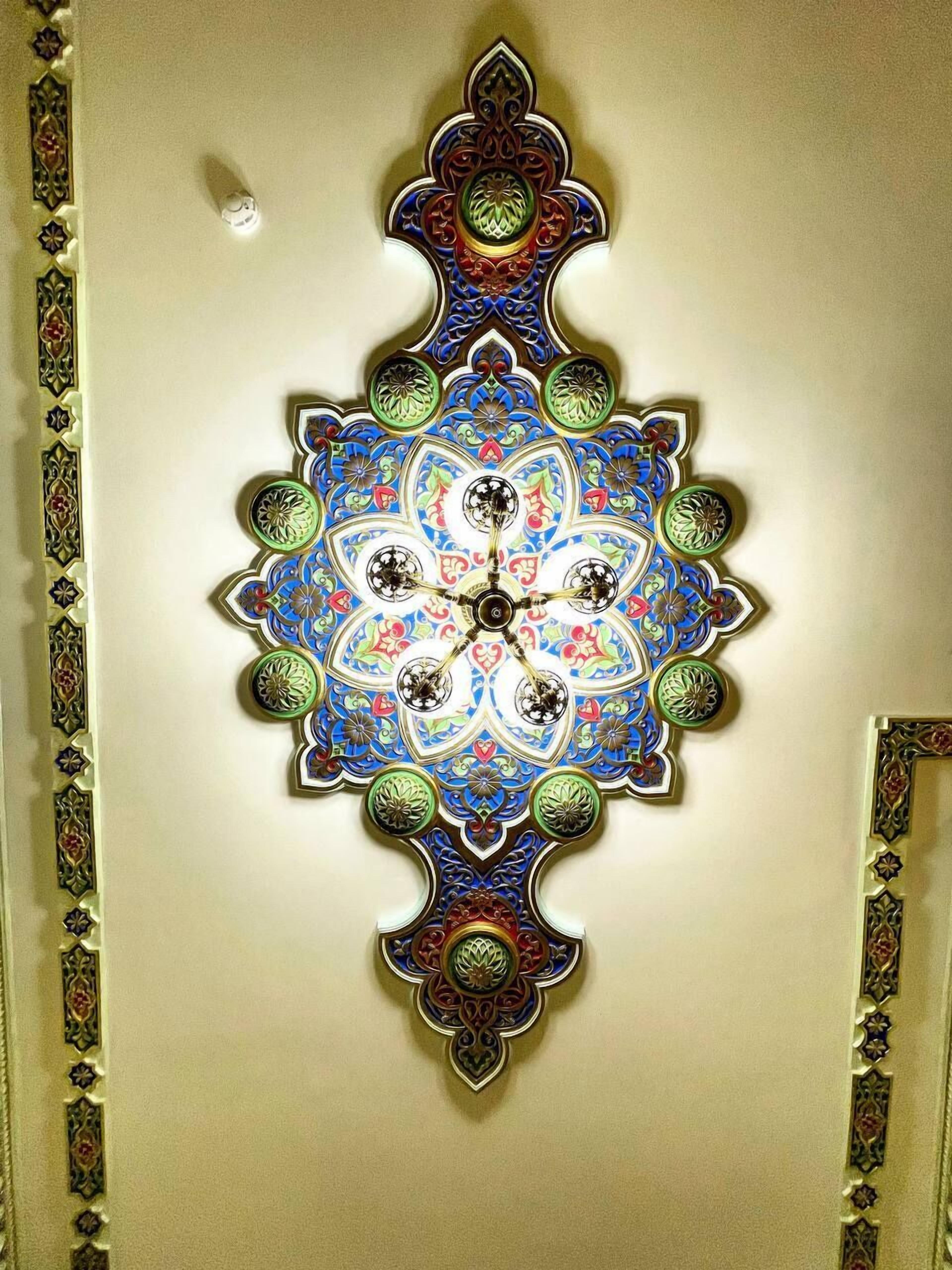 A wall with a decorative, symmetrical, multi-colored geometric pattern.