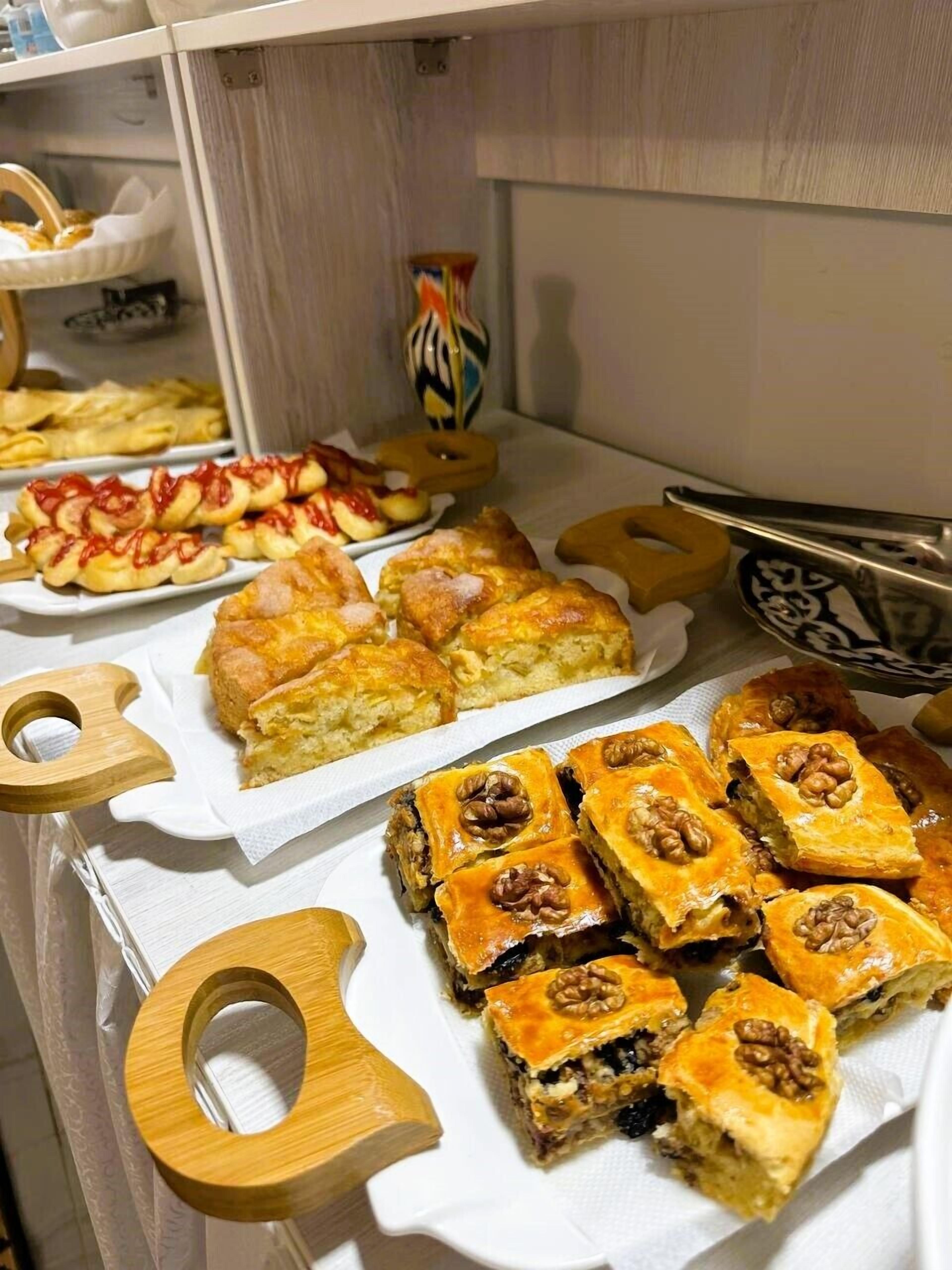 Diverse gebakjes en zoetigheden op een tafel, waaronder een schaal met fruit.