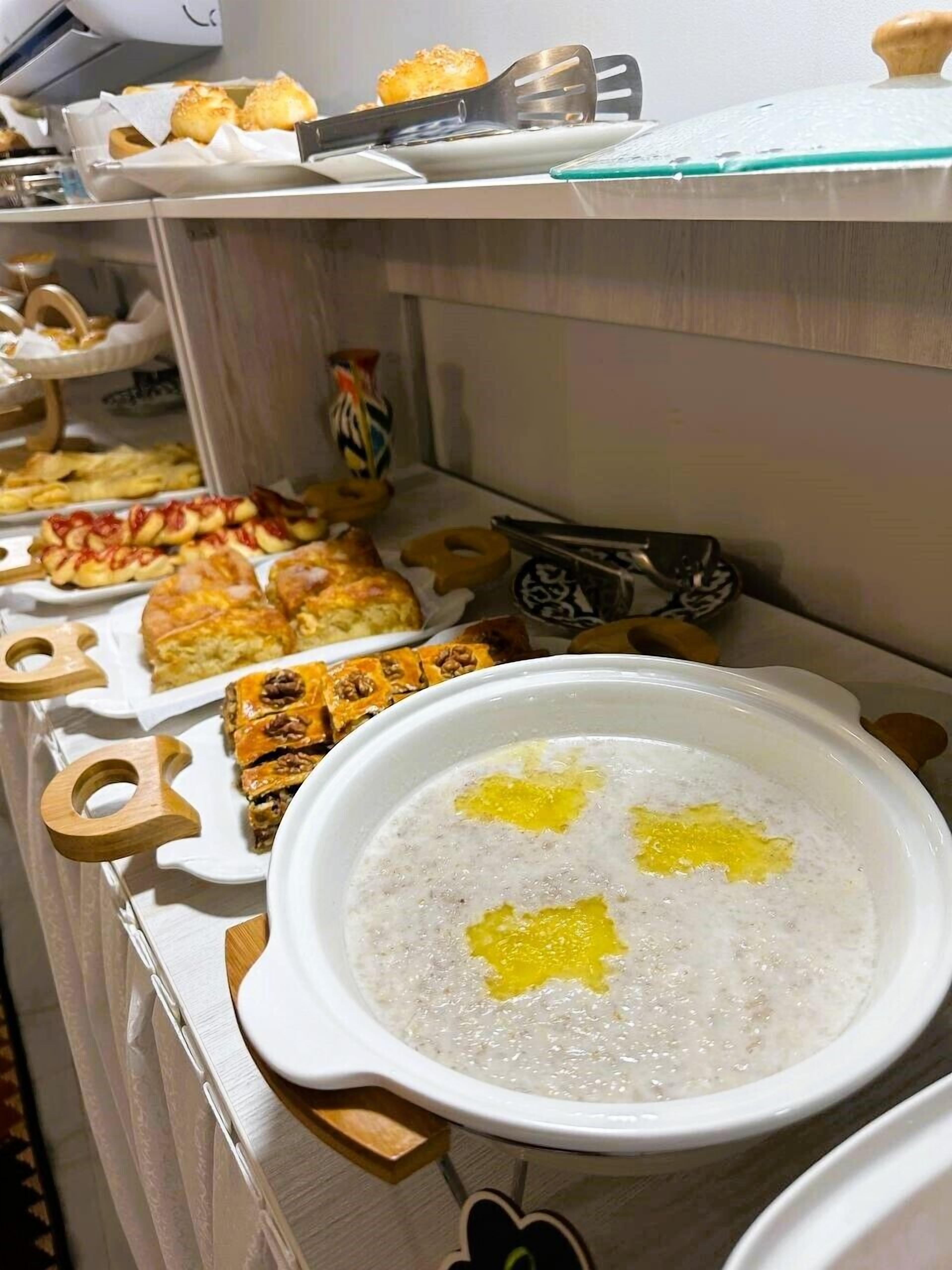A buffet with various dishes including pastries and a bowl of soup.