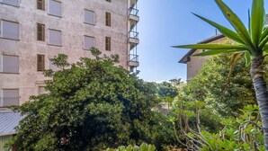 A multi-story building with balconies, surrounded by dense greenery and various plants. - GuestHost - Cozy apartment is located in a strategic position to visit the renowned Ligurian Riviera, suitable for families or groups of friends. Convenient for visiting the nearby towns of the Gulf of Tigullio, such as Chiavari, Santa Margherita and Por (Lavagna)