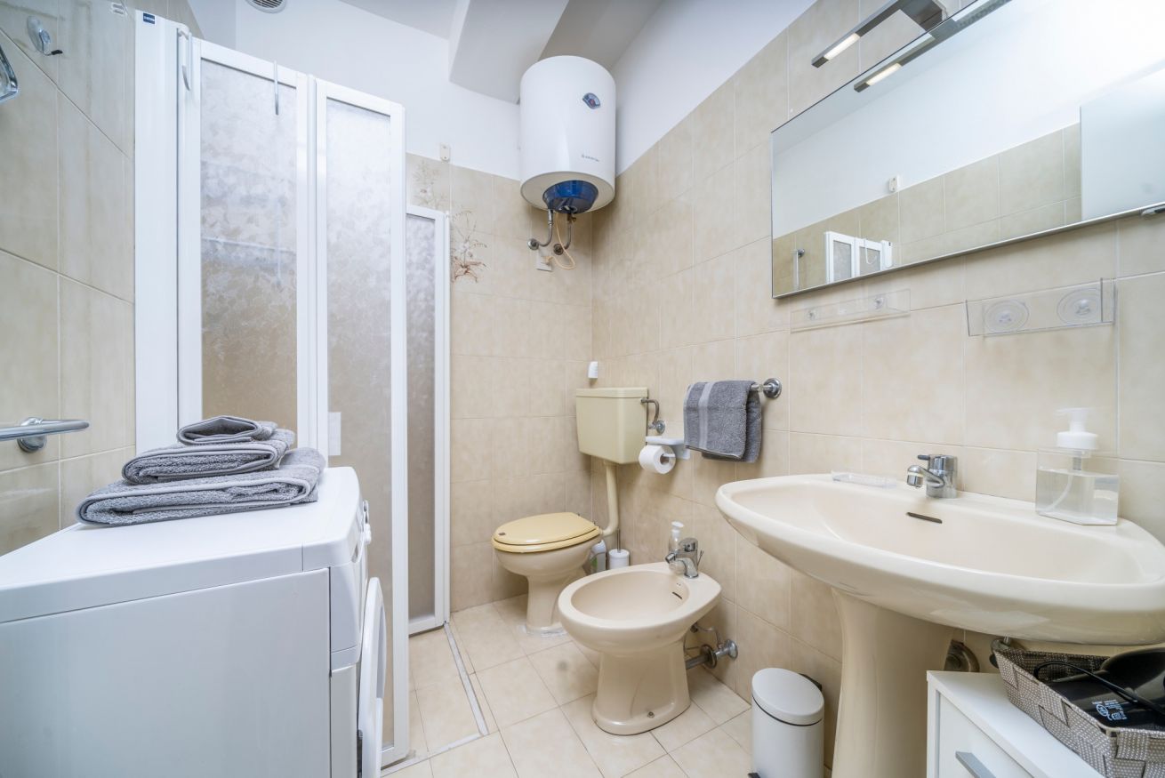 Un bany amb vàter, bidet, rentapel i una barra de tovalloles.