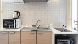 Una cocina moderna con microondas, fregadero y horno tostador integrado.