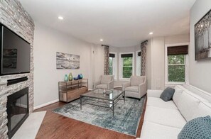 Cozy living room with a fireplace, flat-screen TV, and comfortable seating area.