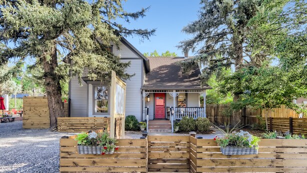 A house with a red door, wooden steps, and a front porch.