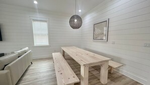 Een moderne woonkamer met een houten eettafel, een bank en een sofa.