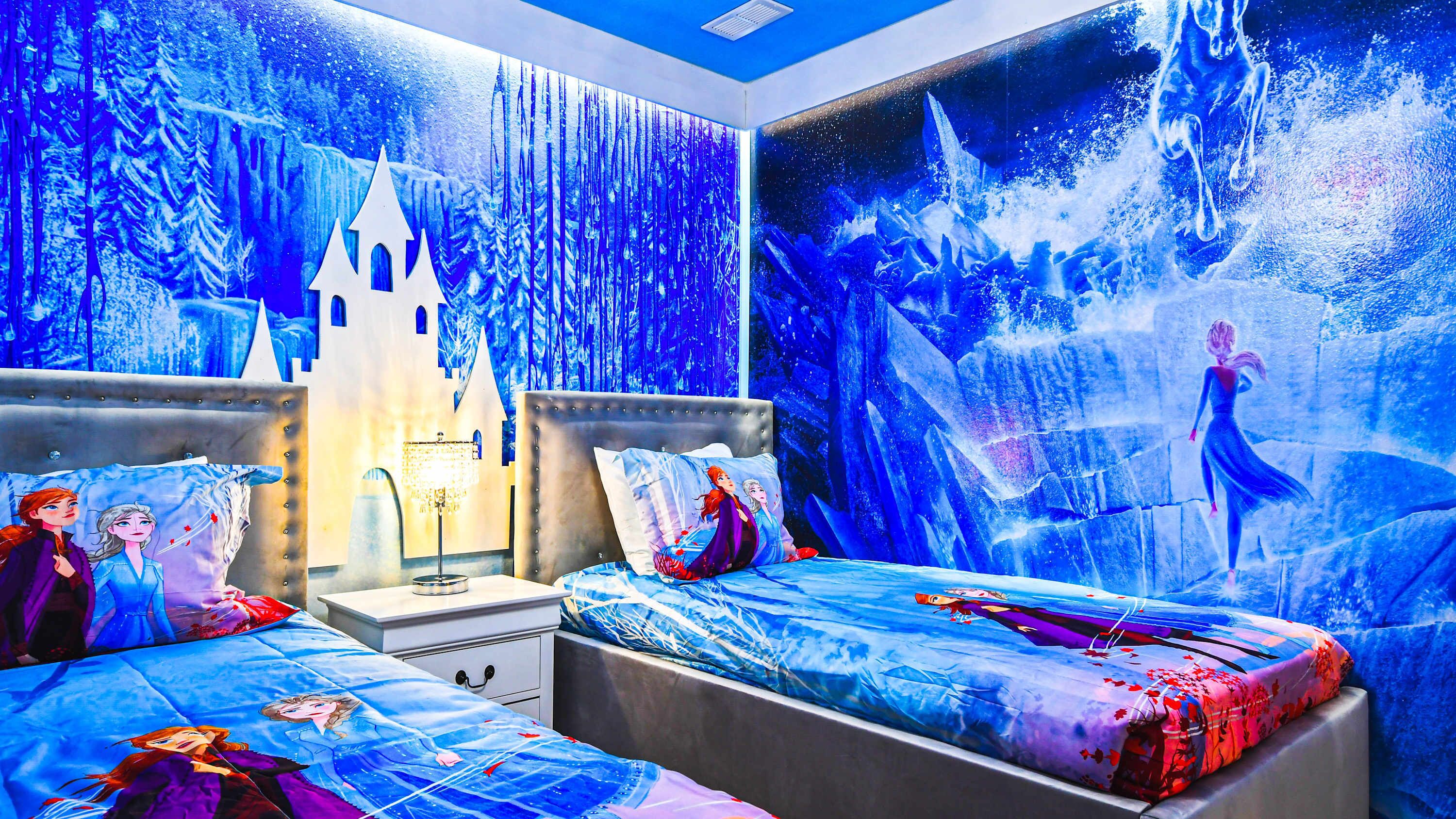 A bedroom with two beds, a nightstand, and a wall mural.