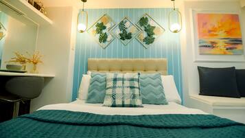 Quarto com cama, escrivaninha, cadeira, prateleira na parede e um quadro.