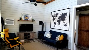 Una sala de estar acogedora con televisor, sofá y sillón.