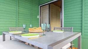 A dining table set with plates, glasses, and a basket, against a green wall. - Sweet home, La Fortuna/ private pool / free concierge / 5 minutes from downtown (La Fortuna)