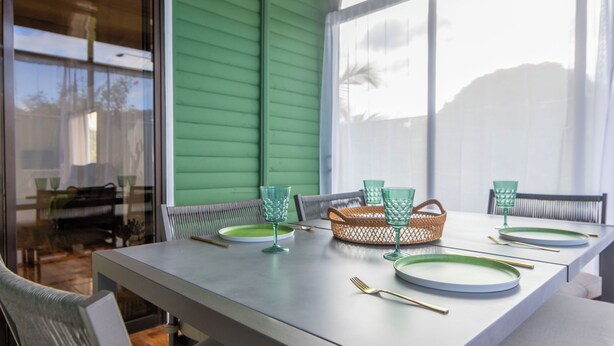 A dining table set with plates, glasses, and cutlery, with a wicker basket and chairs. - Sweet home, La Fortuna/ private pool / free concierge / 5 minutes from downtown (La Fortuna)