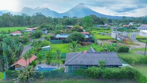 A residential area with houses, a swimming pool, and a mountain in the background.