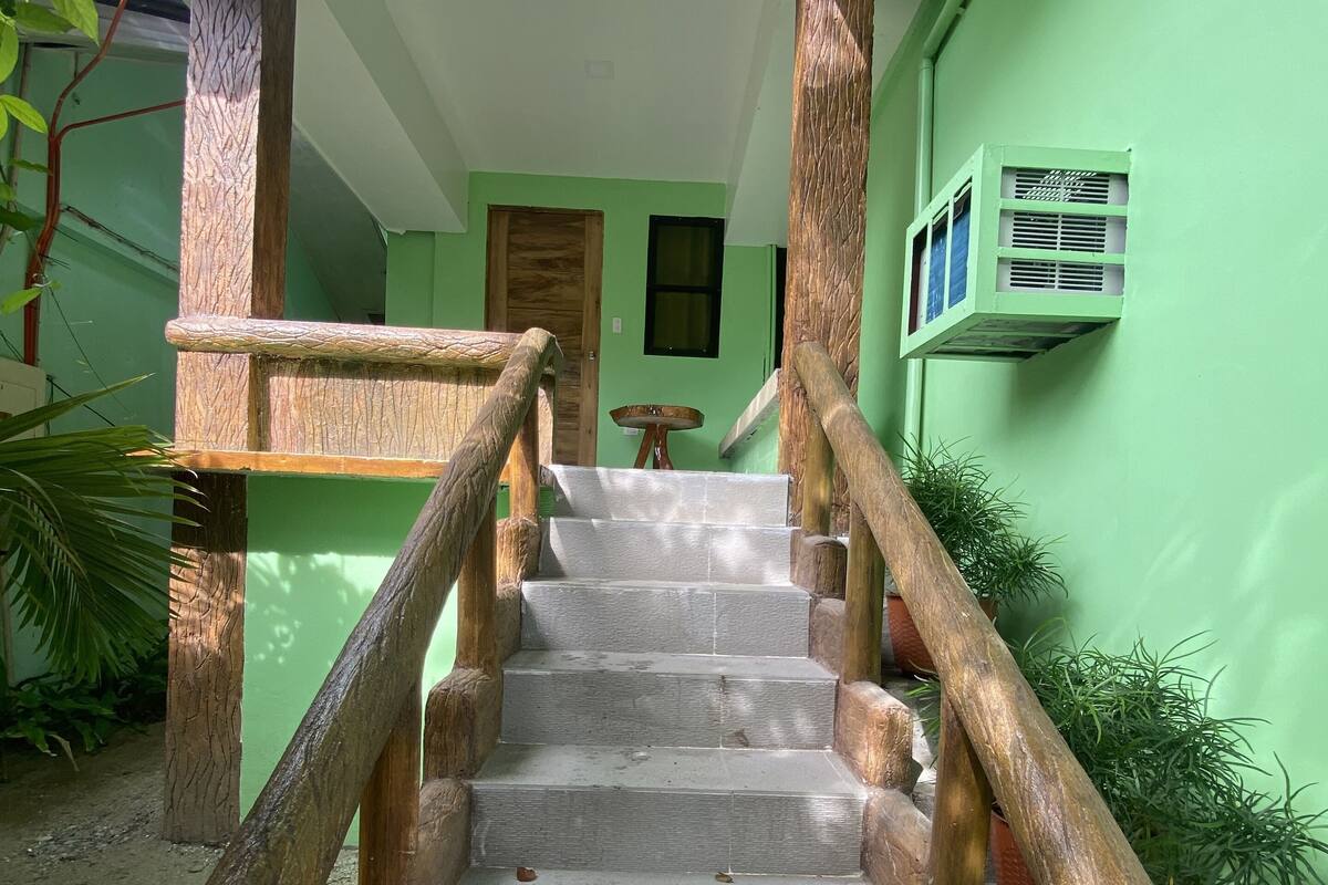 A staircase with wooden railings leading to a room labeled "FLORIDA PALM".