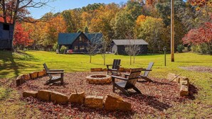 A rustic cabin with a fire pit and Adirondack chairs in a wooded area. - Relax Your Mind, Body and Soul: Escape into Nature (Nelsonville)