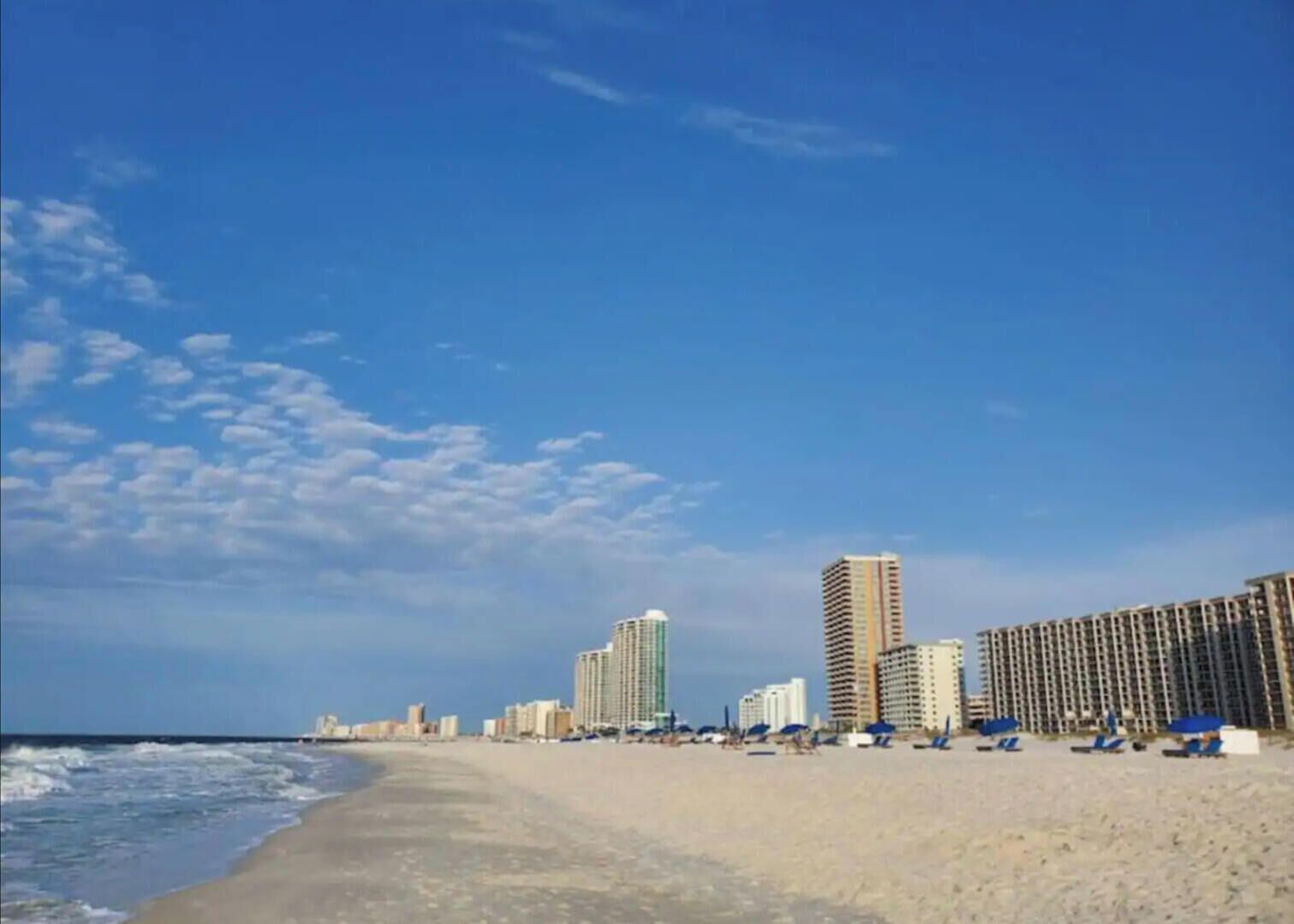 A beach with high-rise buildings in the background.